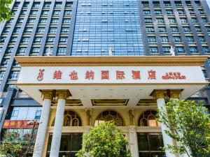 a building with a sign in front of a tall building at Vienna Hotel Shanghai Hongqiao National Convention and Exhibition Center Wanda in Jiading