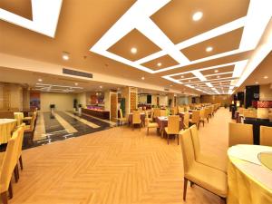 Vienna International Hotel Zhangjiajie Tianmen Mountain في تشانغجياجيه: غرفة طعام مع طاولات وكراسي في مطعم