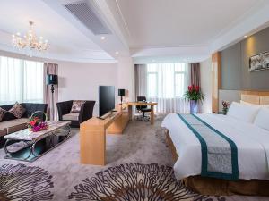 a hotel room with a large bed and a living room at Vienna International Hotel Foshan The World of Flowers in Shunde