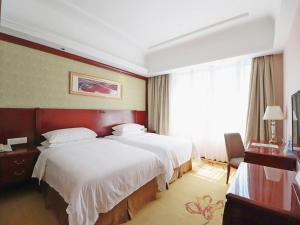 a hotel room with two beds and a window at Vienna Hotel Shanghai Hongqiao National Convention Centre in Shanghai