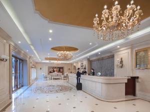 a man standing in a hotel lobby with a bar at Vienna Hotel Nanjing Baijiahu Ximenzi in Nanjing