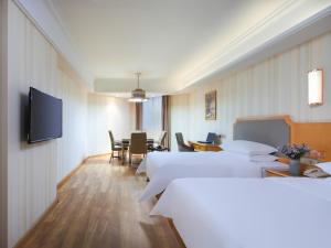 een ziekenhuiskamer met witte bedden en een tv bij Vienna 3 good hotel (Anhui Ningguo store) in Ningguo