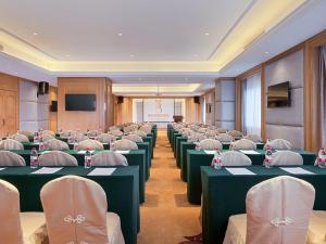 einen Konferenzraum mit grünen Tischen und weißen Stühlen in der Unterkunft vienna Hotel (fujian quanzhou dehua station) in Dehua