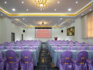 深圳的住宿－維也納國際酒店深圳坂田環城南路店，一间会议室,配有紫色的桌椅和屏幕