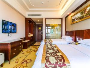 a hotel room with two beds and a desk at Vienna Hotel Shanghai Hongqiao National Convention and Exhibition Center Wanda in Jiading