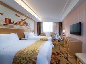 a hotel room with two beds and a flat screen tv at Vienna 3 Best Hotel Guangzhou Panyu Jinjiang Ave in Guangzhou