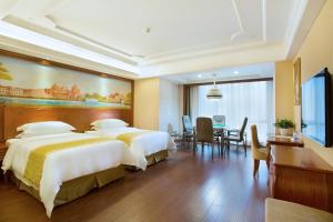 a hotel room with two beds and a dining room at Vienna International Hotel Changsha Hongxing in Changsha