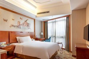 a hotel room with a large bed and a window at Vienna International Hotel Foshan Qiandeng Lake in Foshan