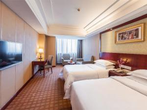 Habitación de hotel con 2 camas y TV de pantalla plana. en Vienna Hotel Shanghai Baoshan Wusong, en Shanghái