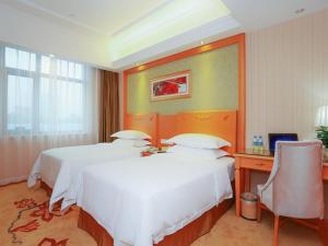 Кровать или кровати в номере Vienna Hotel Tianjin Huanghe Road