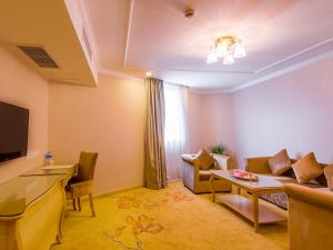 a living room with a couch and a table at Vienna International Hotel Shanghai Jinqiao Industrial Park North Yanggao Road in Shanghai