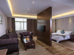 a hotel room with a bed and a couch at Vienna Hotel Nanning Jiangnan Wanda in Nanning