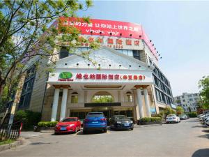 un bâtiment avec des voitures garées devant lui dans l'établissement Vienna Hotel Shanghai Pudong Airport Huaxia Road, à Shanghai