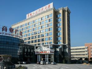 um grande edifício com uma placa em frente em Vienna Hotel Shanghai Hongqiao Convention & Exhibition Center em Xangai