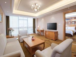 a living room with a room with a bed and a television at Vienna Hotel Guangdong Heyuan Lianping in Lianping