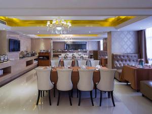 a dining room with a long table and chairs at Vienna International Hotel Guangdong Foshan Nanhai Heshun in Nanhai