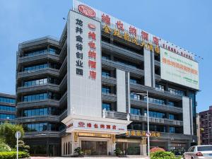 Un gran edificio con un cartel al costado. en Vienna Hotel Shenzhen Longzhu, en Shenzhen