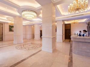 duży hol z kolumnami i żyrandolem w obiekcie Vienna 3 Best Hotel Meizhou Mei County People Square w Meizhou