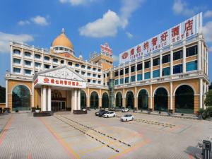 a large building with cars parked in a parking lot at Vienna Hotel Guangzhou Jinshazhou in Nanhai