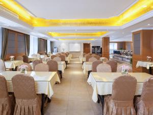 a dining room with tables and chairs in a restaurant at Vienna International Hotel Changsha Shumuling Subway Station in Changsha