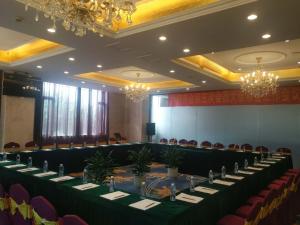 una sala conferenze con tavoli, sedie e lampadari a braccio di Vienna Hotel (Quanzhou West Lake Store) a Quanzhou