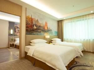 three beds in a room with a painting on the wall at Vienna International Hotel Xian High Technology Road in Xi'an