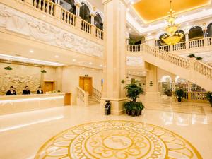 a large lobby with a staircase in a building at Vienna Hotel Changsha Jingwanzi Middle Mulian Road in Changsha