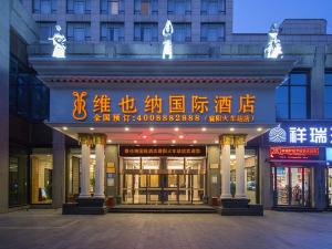 a building with writing on the front of it at Vienna International Hotel Xiangyang Railway Station in Xiangyang