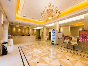 a hotel lobby with a chandelier and a check in counter at Vienna 3 Best Hotel Hubei Jingmen Huyaguan Avenue Changfa in Jingmen