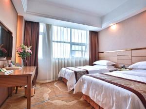 a hotel room with two beds and a desk at Vienna International Hotel Huhan Jiedaokou in Wuhan +4 photos