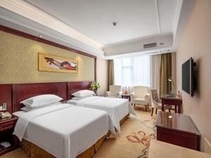 a hotel room with two beds and a television at Vienna Hotel Guilin North Road in Guilin