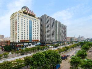 a city with tall buildings and a street with cars at Vienna Hotel Dongguan Chang'an Mid Zhen'an Road in Dongguan