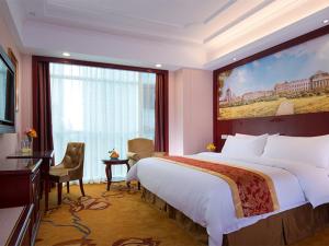 a hotel room with a large bed and a large window at Vienna Hotel Shenzhen Exhibitian Center 2nd in Shenzhen