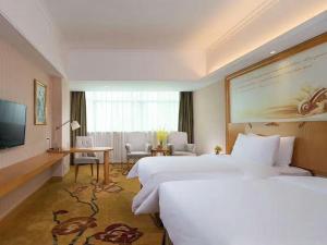 a hotel room with two beds and a television at Vienna Hotel (Huizhou Daya Bay Xinyi Store) in Huizhou