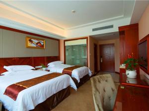 上海市にあるウィーン ホテル 上海 浦東空港 華夏路のベッド2台と窓が備わるホテルルームです。