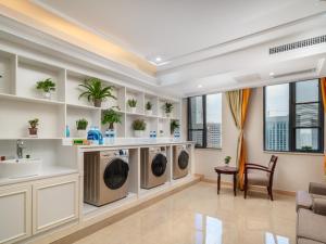 a laundry room with two washers and a sink at Vienna Hotel Guiyang Exhibition Center in Guiyang