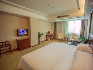 a hotel room with a large bed and a television at Vienna Hotel Shenzhen BaoAn Qianjin Road in Bao'an