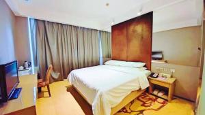 1 dormitorio con 1 cama grande y TV en Vienna International Hotel Shanghai Hongkou Guangyue Road en Shanghái