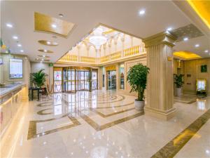 een groot gebouw met een lobby met een potplant bij Vienna International Hotel Shanghai Pudong New International Exbition Central in Shanghai