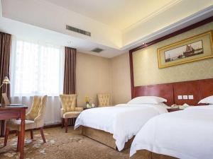 a hotel room with two beds and a desk at Vienna Hotel Chengdu Exhibition Centre in Chengdu