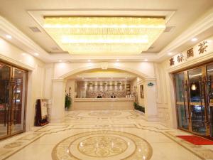 長沙市にあるVienna Hotel Changsha Mid Furong Roadのシャンデリアと大きな敷物が備わる広いロビー