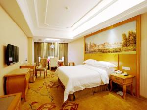 a hotel room with a bed and a dining room at Vienna International Hotel Zhuzhou Railway Station Central Plaza in Zhuzhou +26 photos