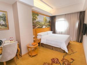 ein Hotelzimmer mit Bett und Schreibtisch in der Unterkunft Vienna Hotel Guangzhou Beijing Road in Guangzhou + 6 Fotos