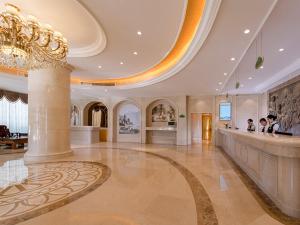 Vienna Hotel Shenzhen Luofang في شنجن: لوبي الفندق كبير وفيه ثريا وبار