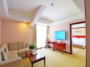 sala de estar con sofá y cama en Vienna Hotel Shanghai Hongqiao National Convention Centre en Shanghái