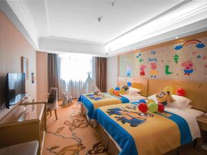 a hotel room with two beds with toys on them at Vienna Hotel Shenzhen Buji Ganli Road in Longgang