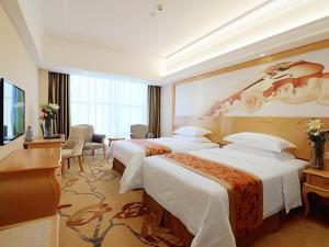 a hotel room with two beds and a television at Vienna Hotel Hunan Yongzhou Lengshuitan District Government Square in Guzhuting