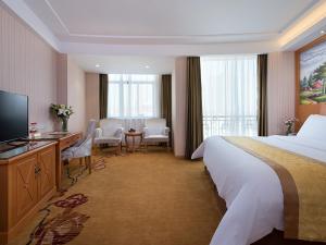 a hotel room with a large bed and a television at Vienna Hotel (Shengzhou Bada Hotel) in Shengzhou +3 photos