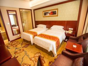a hotel room with two beds and a couch at Vienna Hotel Shanghai Wild Animal Park in Nanhui