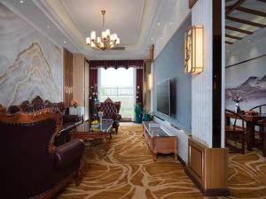 een grote woonkamer met een bank en een televisie bij Vienna Hotel Shantou Chaoyang Mianxi Road in Shantou